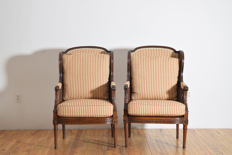 Pair of Carved Walnut and Caned Bergeres